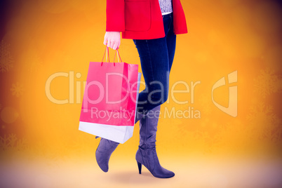 Composite image of happy blonde in winter clothes holding shoppi