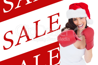 Composite image of festive brunette in boxing gloves punching