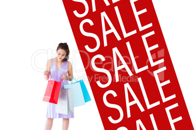 Composite image of stylish brunette in purpul dress opening shop