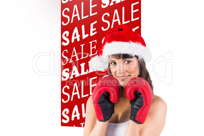 Composite image of festive brunette with boxing gloves