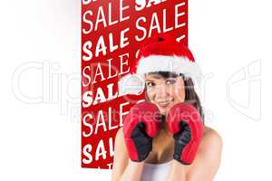 Composite image of festive brunette with boxing gloves