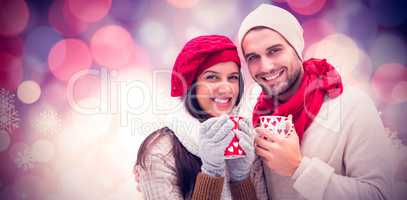 Composite image of winter couple holding mugs