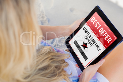 Composite image of woman sitting on beach in deck chair using ta