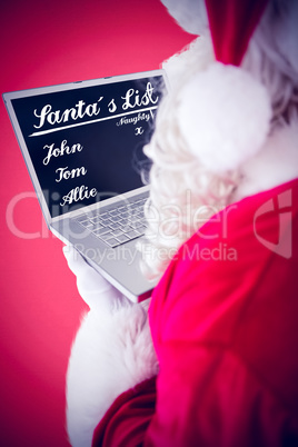 Composite image of santa claus using his laptop