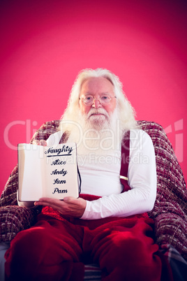 Composite image of father christmas showing a book