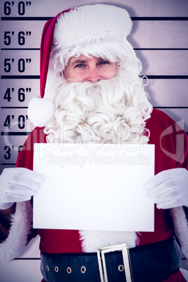 Composite image of cheerful santa claus holding page