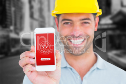 Composite image of portrait of smiling handyman showing smart ph