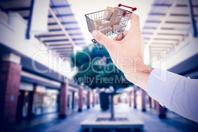 Composite image of businessman holding hand out in presentation