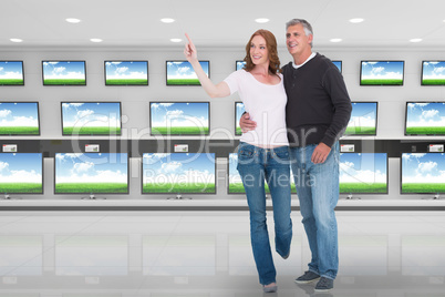 Composite image of casual couple walking and pointing