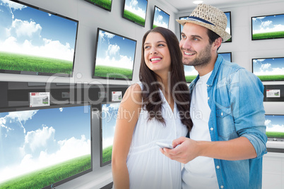 Composite image of happy hipster couple smiling together