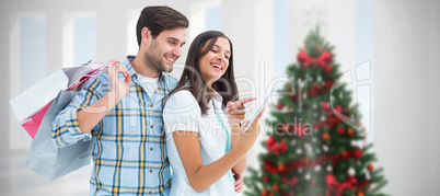 Composite image of happy couple with shopping bags and tablet Composite image of happy couple with shopping bags and tablet