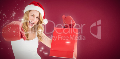 Composite image of festive blonde with boxing gloves and shoppin