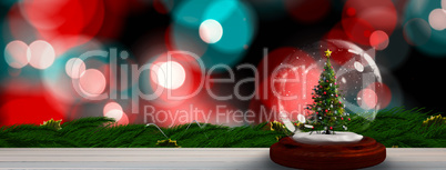 Composite image of christmas tree in snow globe