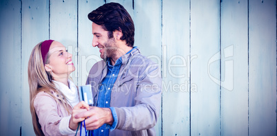 Composite image of smiling couple showing credit card and shoppi