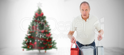 Composite image of shocked man holding shopping bags