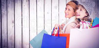 Composite image of beautiful women holding shopping bags looking