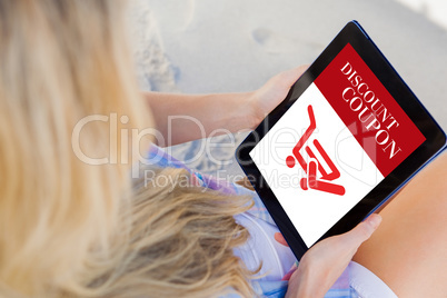Composite image of woman sitting on beach in deck chair using ta Composite image of woman sitting on beach in deck chair using ta