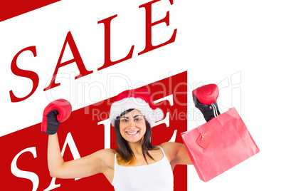Composite image of festive brunette in boxing gloves holding sho