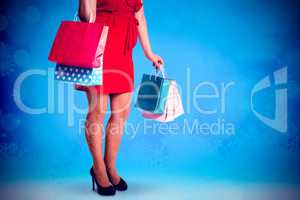 Composite image of woman standing with shopping bags