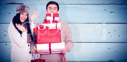 Composite image of young couple with many christmas presents