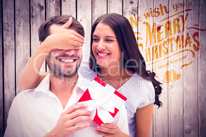 Composite image of woman surprising boyfriend with gift