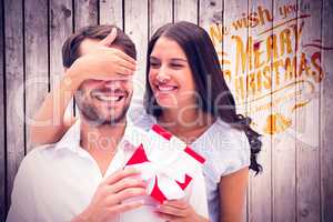 Composite image of woman surprising boyfriend with gift