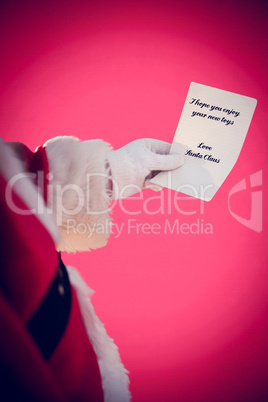 Composite image of father christmas holding a paper