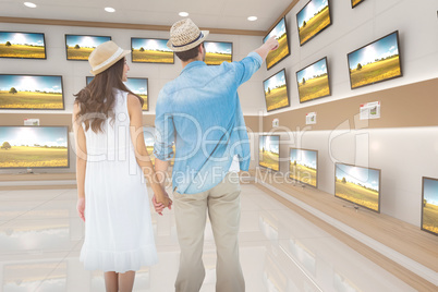 Composite image of happy hipster couple holding hands and lookin