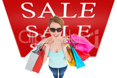 Composite image of woman holding shopping bags wearing sunglasse