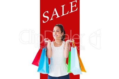 Composite image of happy brunette posing with shopping bags