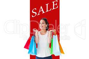 Composite image of happy brunette posing with shopping bags