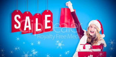 Composite image of festive blonde with shopping bag and gifts