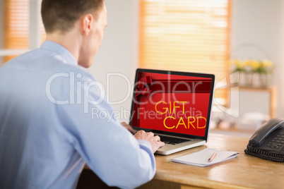 Composite image of businessman working on his laptop