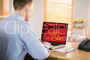 Composite image of businessman working on his laptop