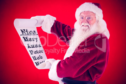 Composite image of father christmas holds a list