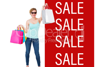 Composite image of woman holding shopping bags wearing sunglasse