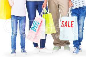 Composite image of family with shopping bags gesturing thumbs up