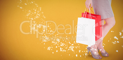 Composite image of elegant brunette posing with shopping bags