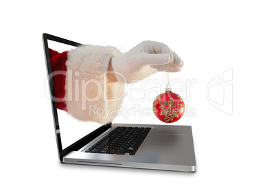 Composite image of santas hand is holding a christmas bulb