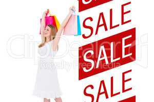 Composite image of excited blonde holding up shopping bags in wh