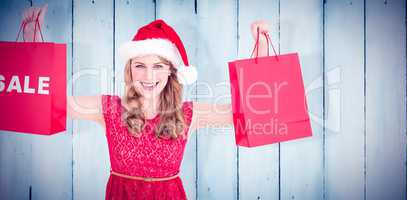 Composite image of festive blonde holding sale shopping bags