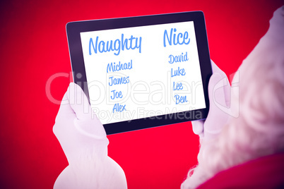 Composite image of santa claus using tablet pc