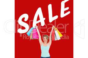 Composite image of excited blonde holding up shopping bags