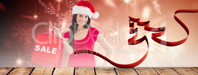 Composite image of festive brunette holding sale bag