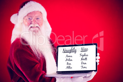 Composite image of santa claus presents a laptop