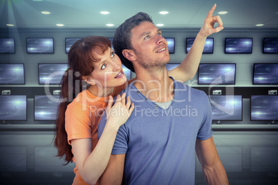 Composite image of happy couple looking upwards