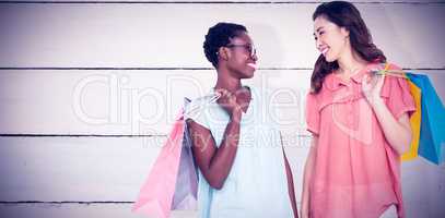 Composite image of female friends holding shopping bags