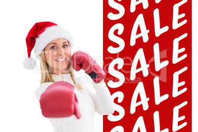 Composite image of festive blonde in boxing gloves