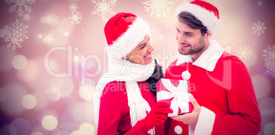 Composite image of festive young couple holding gift