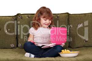 little girl sitting on bed with laptop